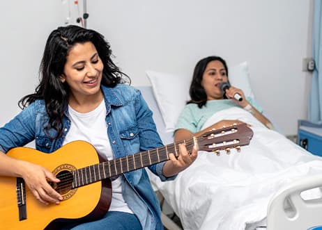 Un musicien jouant de la guitare pour un patient